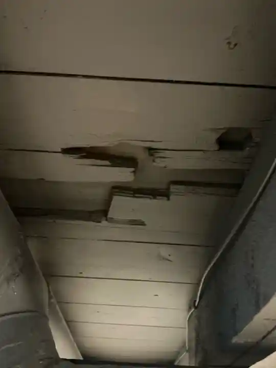 Missing subfloor found at a home inspection in Akron. Two painted areas of the first floor subfloor are shown to have large holes present.